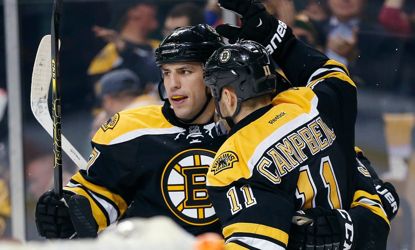 Boston Bruins left wing Milan Lucic, left, celebrates his goal with teammate Gregory Campbell (11) in the second period of an NHL hockey game in against the Minnesota Wild Boston, Tuesday, Oct. 28, 2014. (AP Photo/Michael Dwyer)