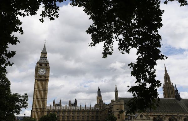 Big Ben is framed by a tree on Parliament Square opposite the Palace of Westminster in London