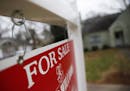 FILE - This Jan. 26, 2016 file photo shows a "For Sale" sign hanging in front of an existing home in Atlanta. Short of savings and burdened by debt, A