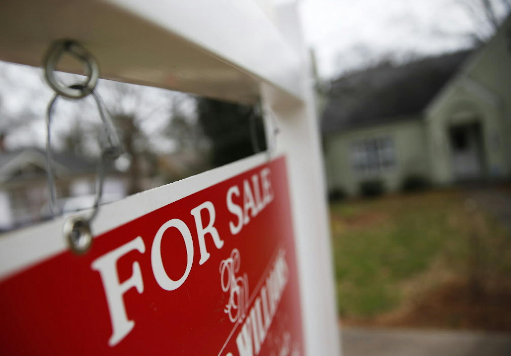 FILE - This Jan. 26, 2016 file photo shows a "For Sale" sign hanging in front of an existing home in Atlanta. Short of savings and burdened by debt, America's millennials are struggling to afford their first homes in the face of sharply higher prices in many of the most desirable cities. Surveys show that most Americans under 35 lack adequate savings for down payments. The result is that many will likely be forced to delay home ownership and to absorb significant debt loads if they do eventually