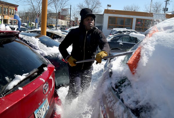 Star King had the unspring-like task of removing snow from vehicles for sale at a used auto lot on Lake St. Wednesday, April 4, 2018, in Minneapolis, 