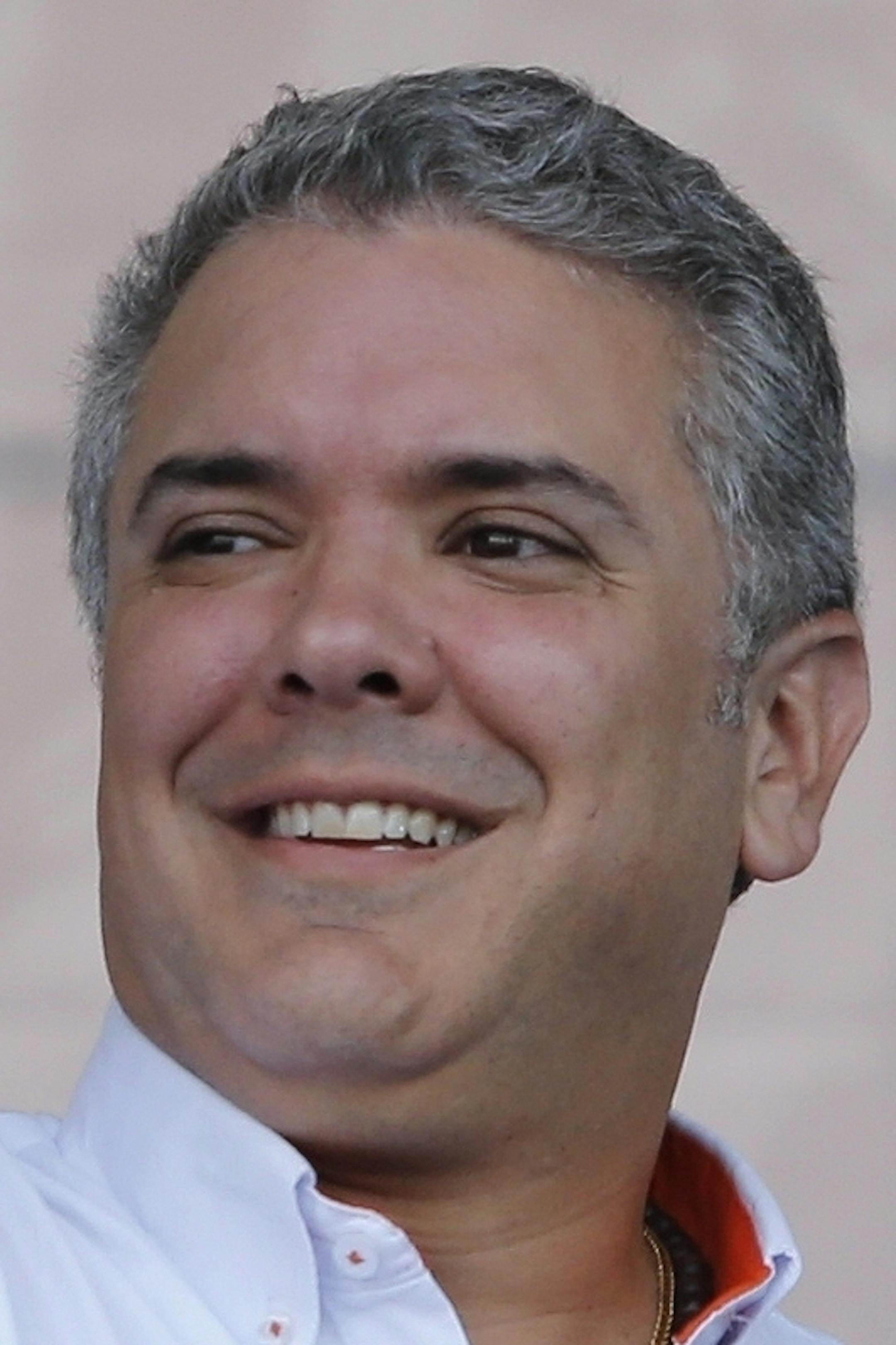 FILE- In this May 12, 2018 file photo, Ivan Duque, presidential candidate for Democratic Center, raises his fist during a campaign rally in Soacha, on the outskirts of Bogota, Colombia. As the presidential front runner, Duque, the son of a former governor and energy minister, has had political aspirations running in his blood. (AP Photo/Fernando Vergara, File)