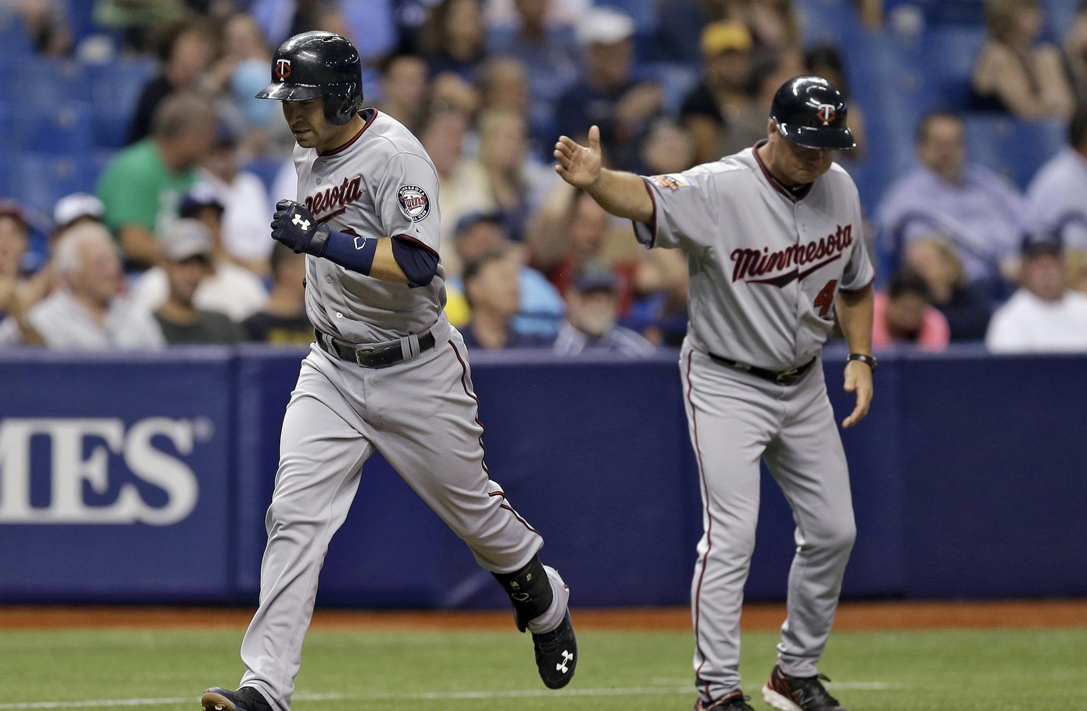 Minnesota Twins' Brian Dozier, left, gets a handshake from third base coach Joe Vavra after hitting a home run off Tampa Bay Rays starting pitcher David Price during fourth inning of a baseball game Tuesday, April 22, 2014, in St. Petersburg, Fla. (AP Photo/Chris O'Meara)