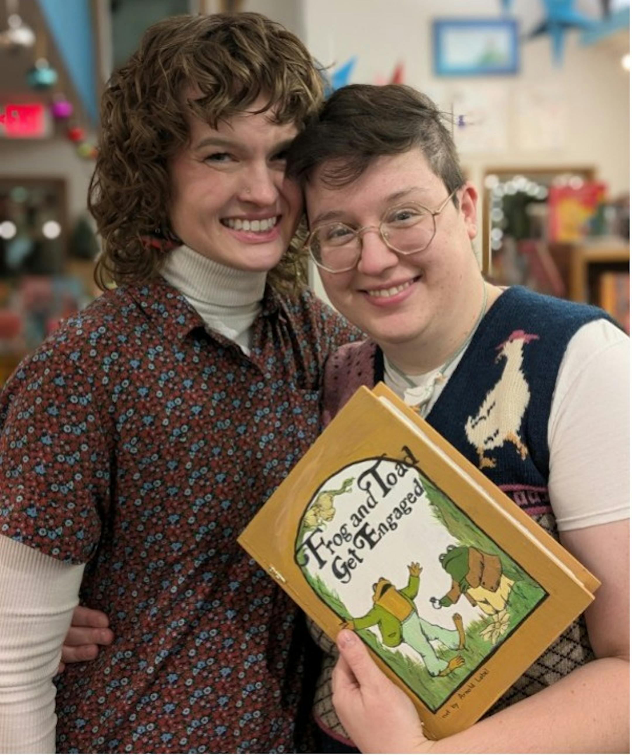 Two people with a book, "Frog and Toad Get Engaged"