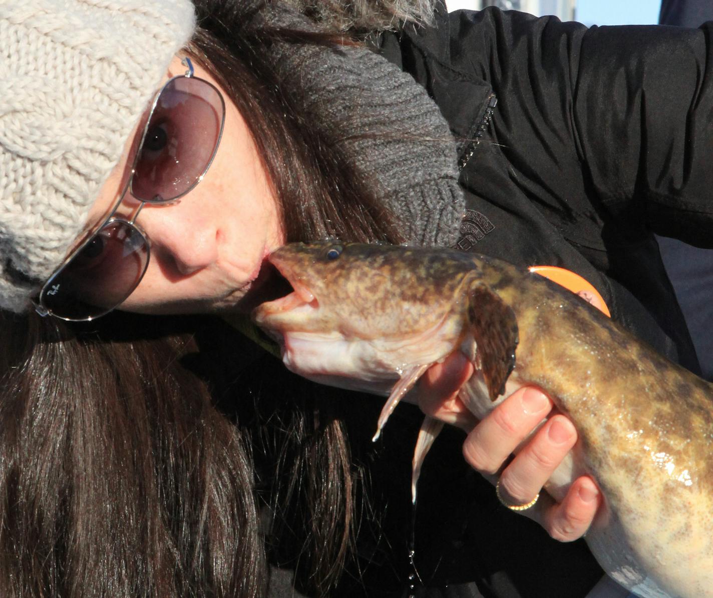 Kelly Plummer of the Twin Cities, planting a kiss on an eelpout.