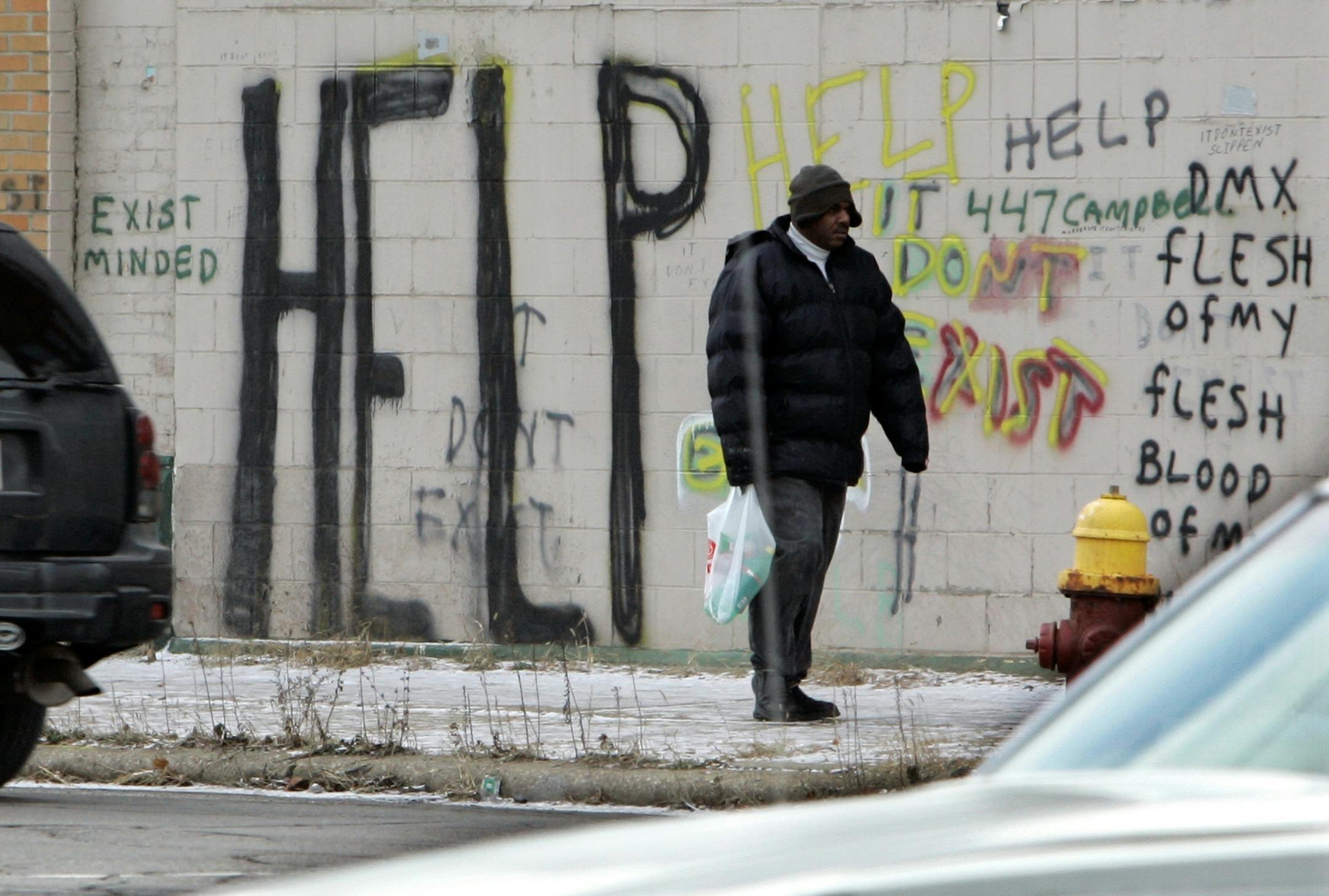 File photo: A pedestrian walks by graffiti in downtown Detroit.