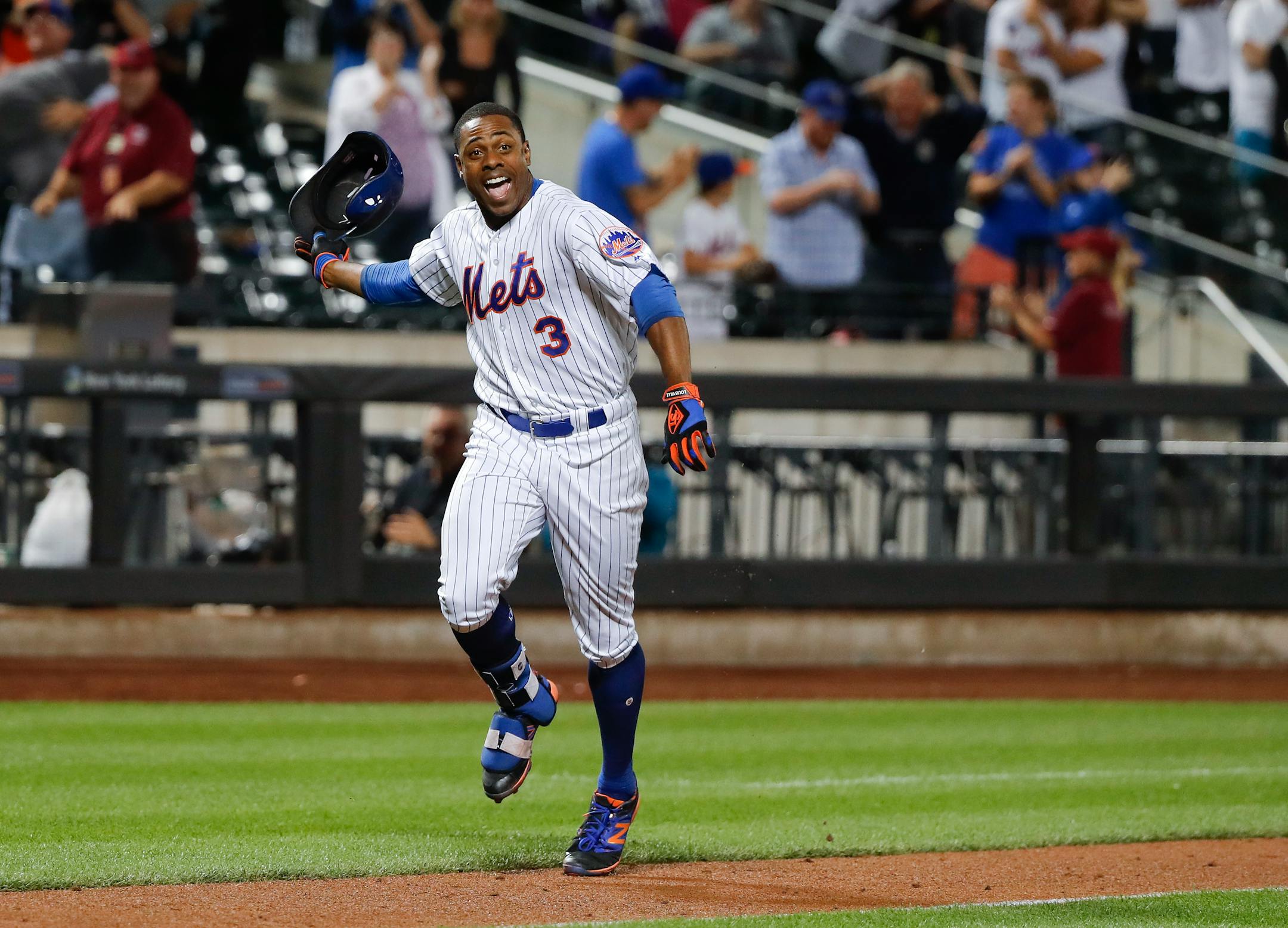 New York Mets' Curtis Granderson (3) tosses his batting helmet as he heads down the third base line after hitting a walk off solo home run against the Minnesota Twins to win the game during the twelfth inning of a baseball game, Saturday, Sept. 17, 2016, in New York. The Mets won 3-2. (AP Photo/Julie Jacobson)