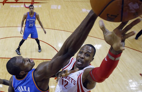 Houston Rockets' Dwight Howard (12) shoots as Oklahoma City Thunder's Serge Ibaka (9) defends during the first quarter of an NBA basketball game, Thur