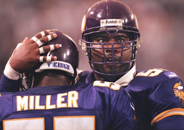 Vikings defensive end Chris Doleman, right, congratulates teammate Corey Miller after Miller intercepted a pass in 1999.
