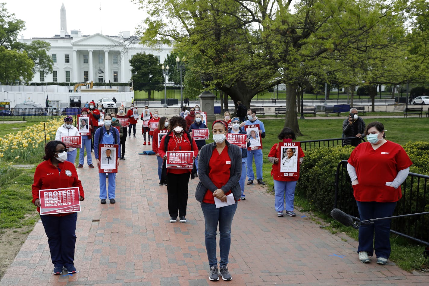 Nurses from National Nurses United practice social distancing as they protest in front of the White House, Tuesday, April 21, 2020, in Washington. The group sought to bring attention to health care workers across the country who have contracted COVID-19 due to a lack of personal protective equipment. (AP Photo/Patrick Semansky)