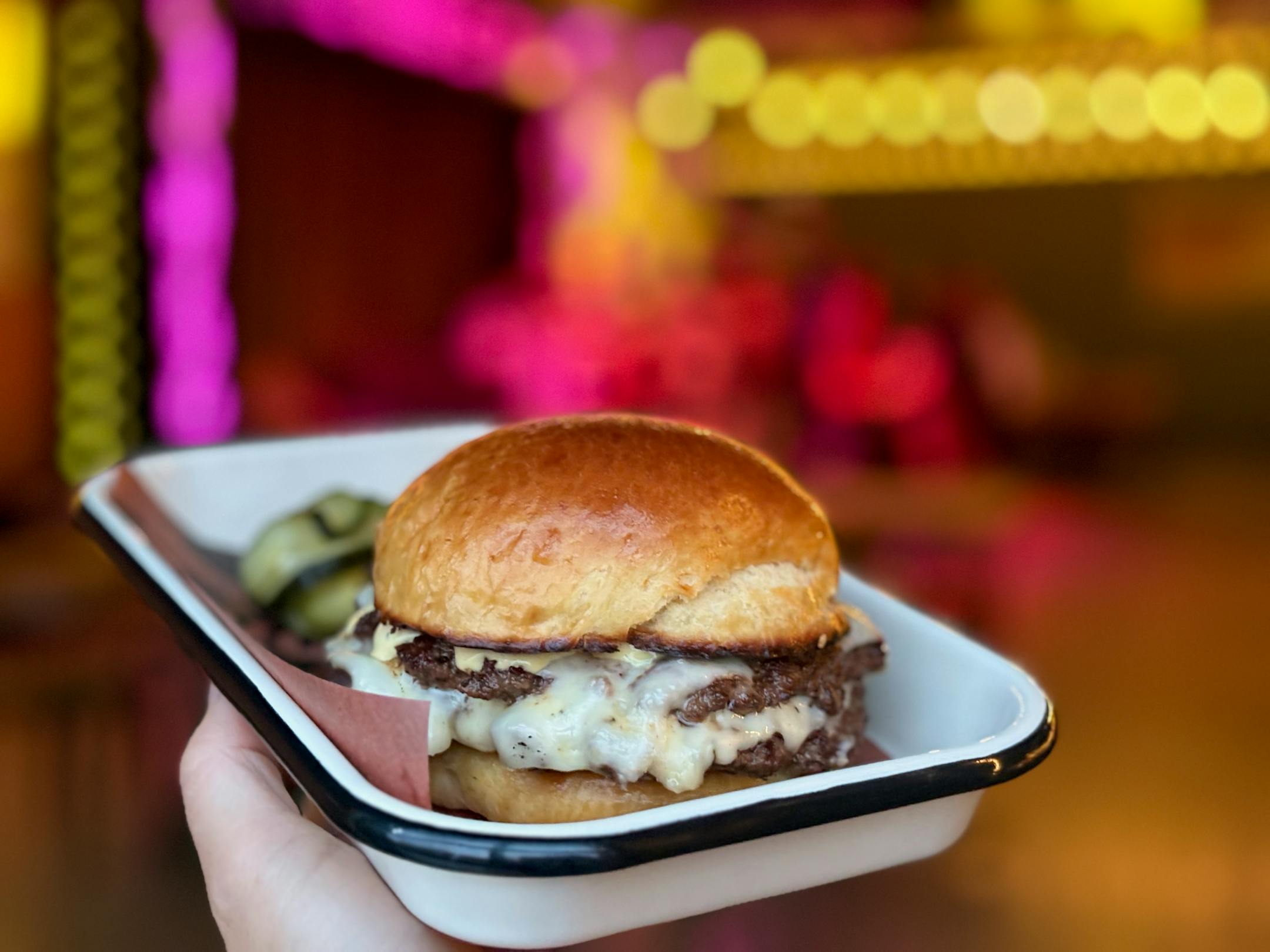 A small try holds the double Waygu beef patty burger inside the new Northeast restaurant.