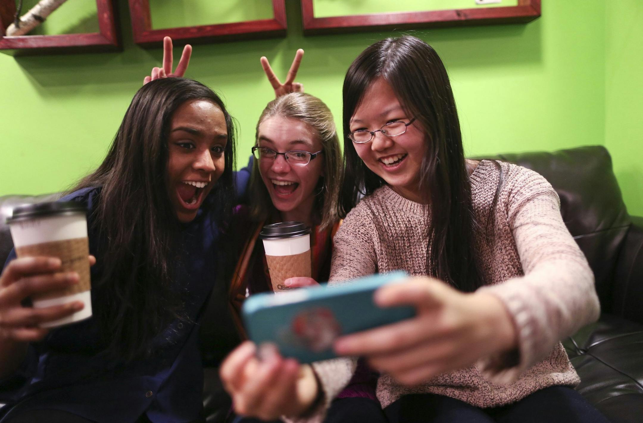 Friends Amrita Mohanty, 16, from left, Marta Williams, 16, and Michelle Mao, 15, take a Snapchat "selfie" while having coffee at the Steepery Tea Bar in Woodbury, Minn., Dec. 12, 2013. (Renee Jones Schneider/Minneapolis Star Tribune/MCT) ORG XMIT: 1146818