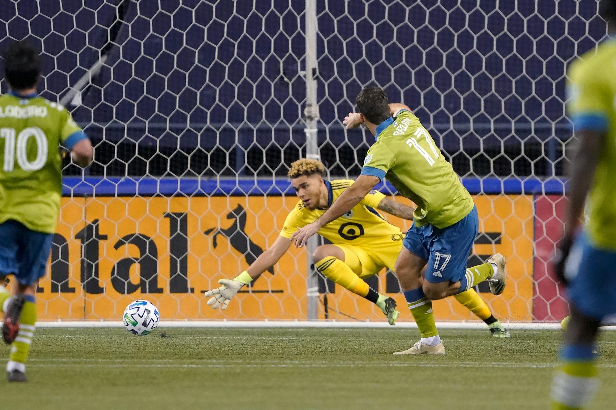 Seattle Sounders forward Will Bruin (17) watches his shot go past Minnesota United goalkeeper Dayne St. Clair as he scores during the second half of an MLS playoff Western Conference final soccer match, Monday, Dec. 7, 2020, in Seattle. (AP Photo/Ted S. Warren)