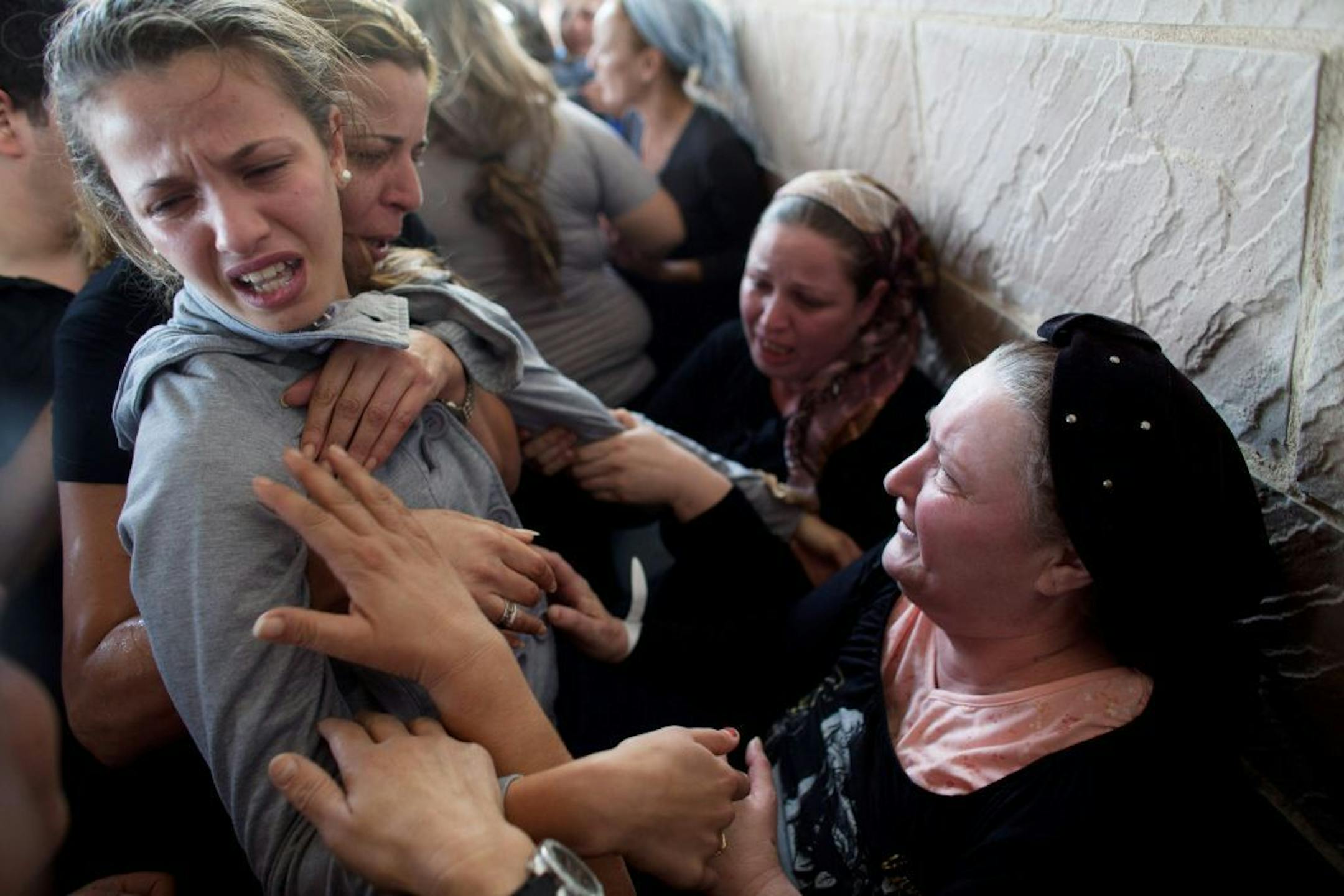 KIRYAT MALACHI, ISRAEL - NOVEMBER 16: (ISRAEL OUT) Relatives grieve at the funeral for Itzik Amsalem, 49, one of the three people who died in a rocket attack on November 16, 2012 in Kiryat Malachi, Israel. Three people were killed in Israel November 15, after a building was hit by a rocket fired from the Hamas-ruled Gaza Strip. Palestinian rocket attacks followed a series aerial strikes on targets in Gaza launched by Israeli Defense Forces (IDF) which killed a top military commander of Hamas.