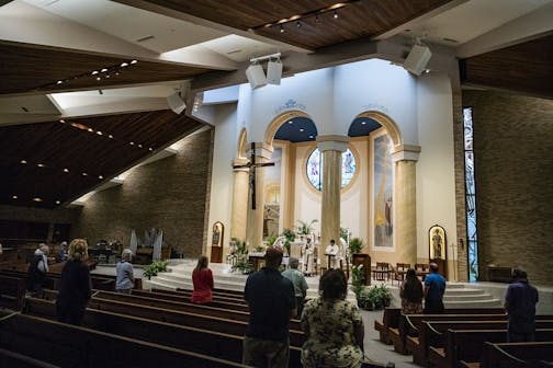 At Transfiguration Catholic Church in Oakdale, parishioners were able to attend a service by Father John Paul Erickson on Wednesday as pews were closed off to allow social distancing and a maximum capacity of 250 or less than 25%.