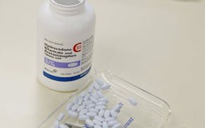 In this Aug. 5, 2010, file photo, a pharmacy technician poses for a picture with hydrocodone and acetaminophen tablets, also known as Vicodin, at the 