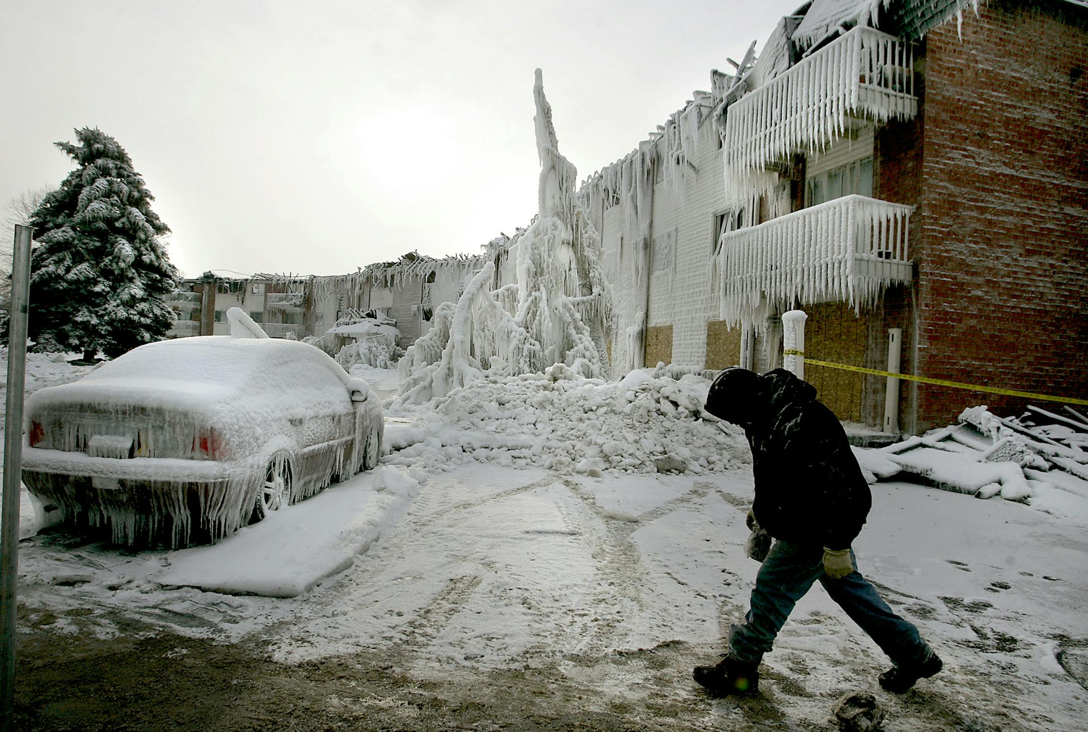 ELIZABETH FLORES eflores@startribune.com December 24, 2008 - Burnsville, MN - Fence builders made their way around the damaged Burncliff Apartments while checks were being distributed to displaced homeowners in the office of the remaining building, Building B of the Burncliff Apartments. Displaced tenants were greeted with a large check by an anonymous donor.