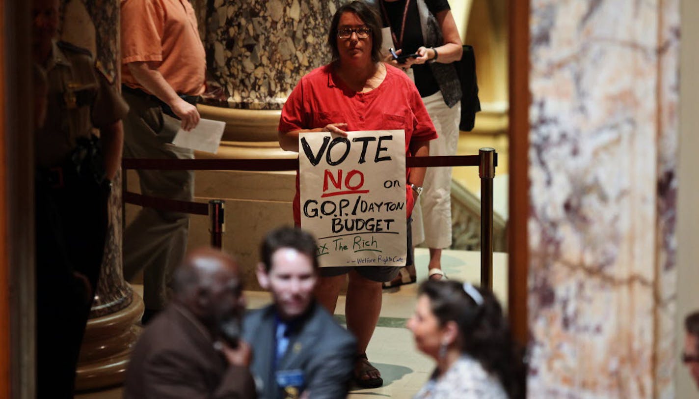 A protester holds a sign outside the Senate chamber at the State Capitol in St. Paul, Minn., Tuesday.