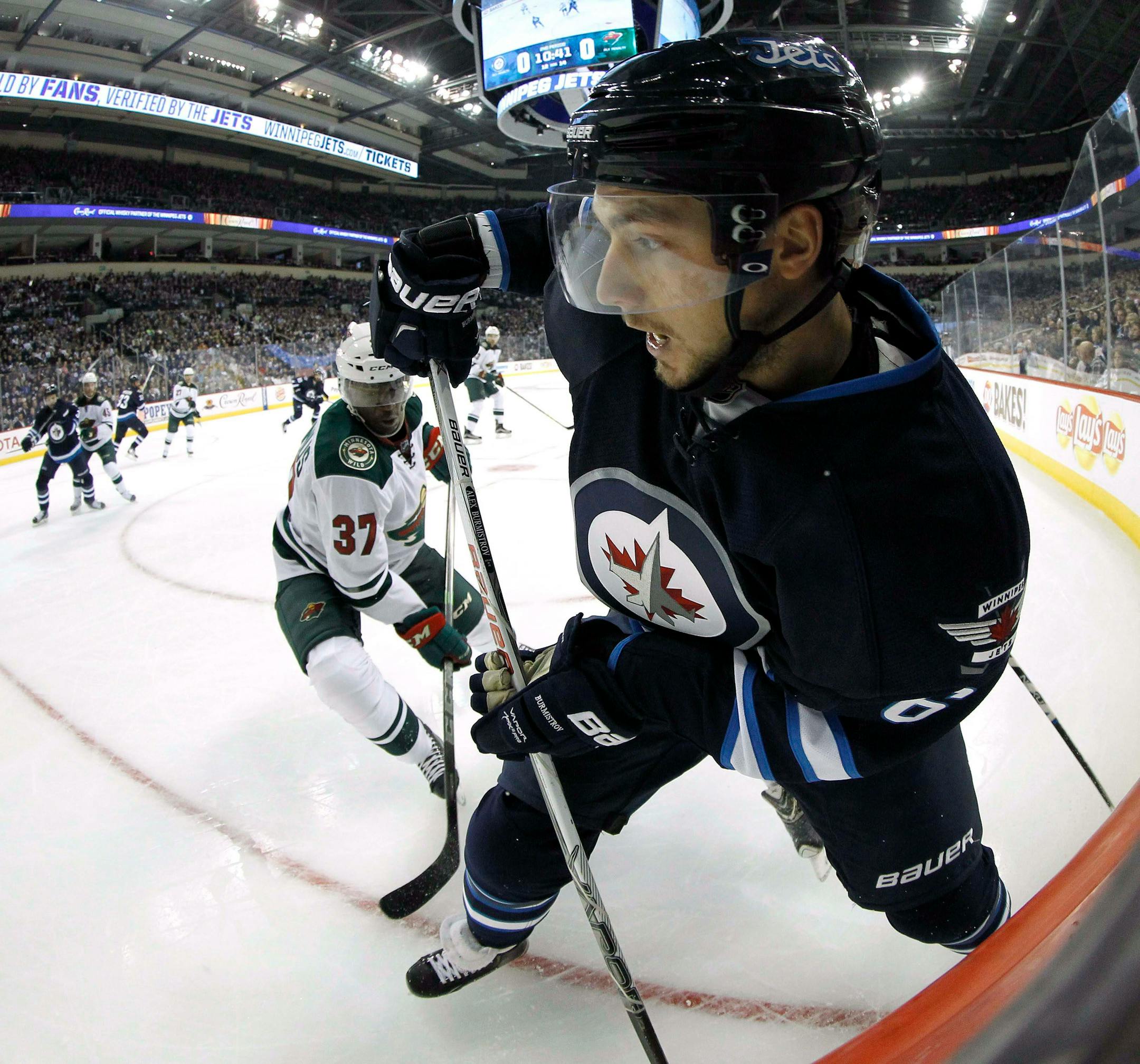 Winnipeg Jets' Alexander Burmistrov, right, plays the puck in front of Minnesota Wild's Maxime Fortunus during the second period of an NHL preseason hockey game Tuesday, Sept. 22, 2015, in Winnipeg, Manitoba. (Trevor Hagan/The Canadian Press via AP) MANDATORY CREDIT