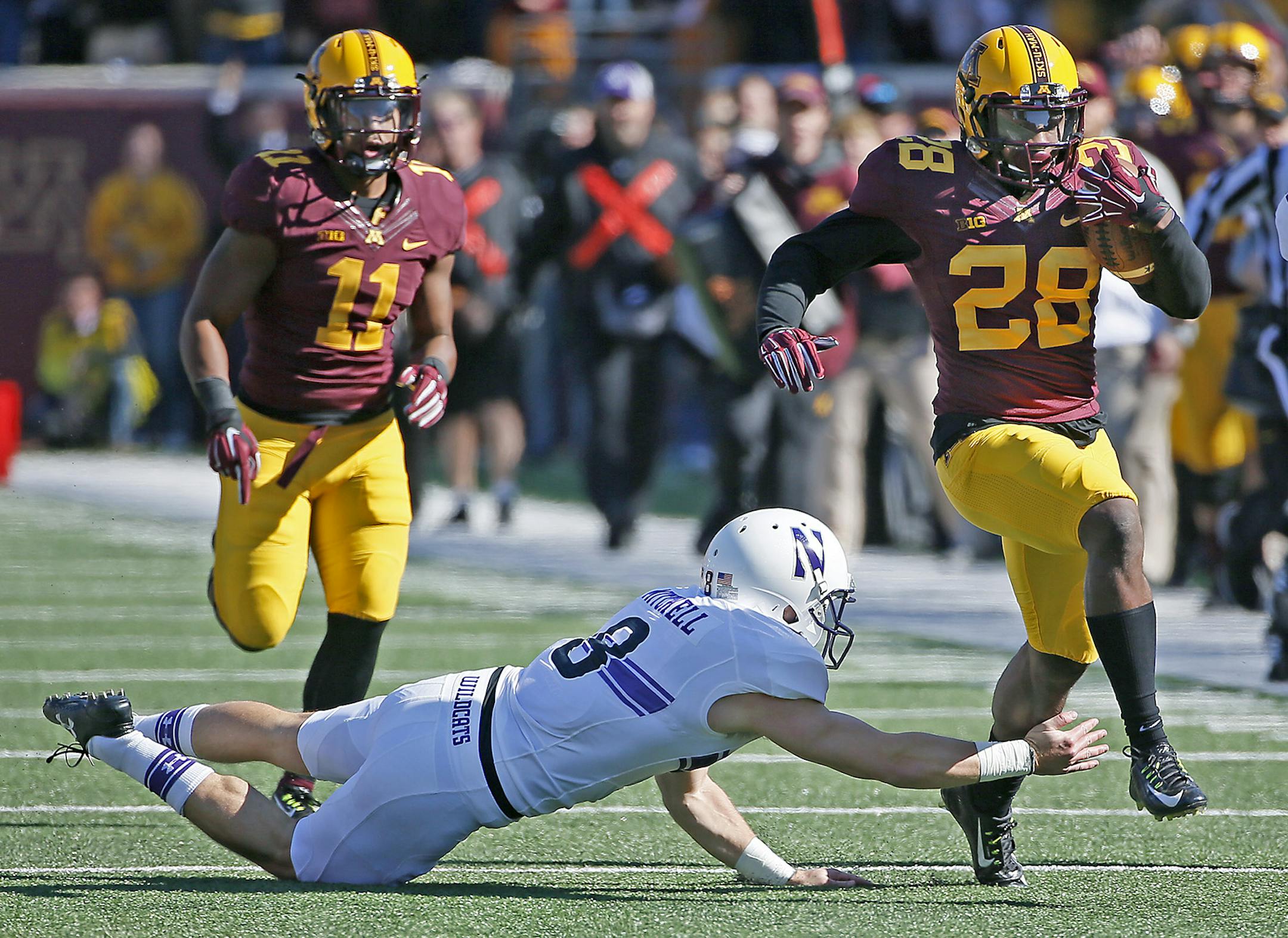 Gophers defensive back Jalen Myrick (28) ran for a 100-yard touchdown return despite defensive pressure including that of Northwestern's place kicker Jack Mitchell (8) in the fourth quarter as the Minnesota Gophers took on the Northwestern Wildcats at TCF Stadium, Saturday, October 11, 2014 in Minneapolis, MN. ] (ELIZABETH FLORES/STAR TRIBUNE) ELIZABETH FLORES • eflores@startribune.com