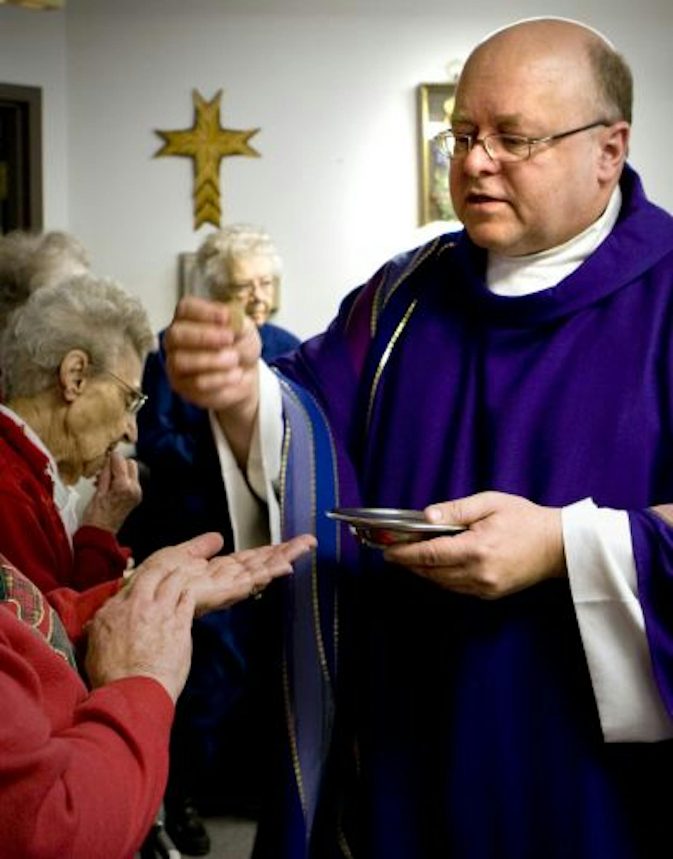 Rev. Chuck Huck distributes the Holy Eucharist during Mass at Sunview, an independent living facility for seniors in Red Lake Falls.
