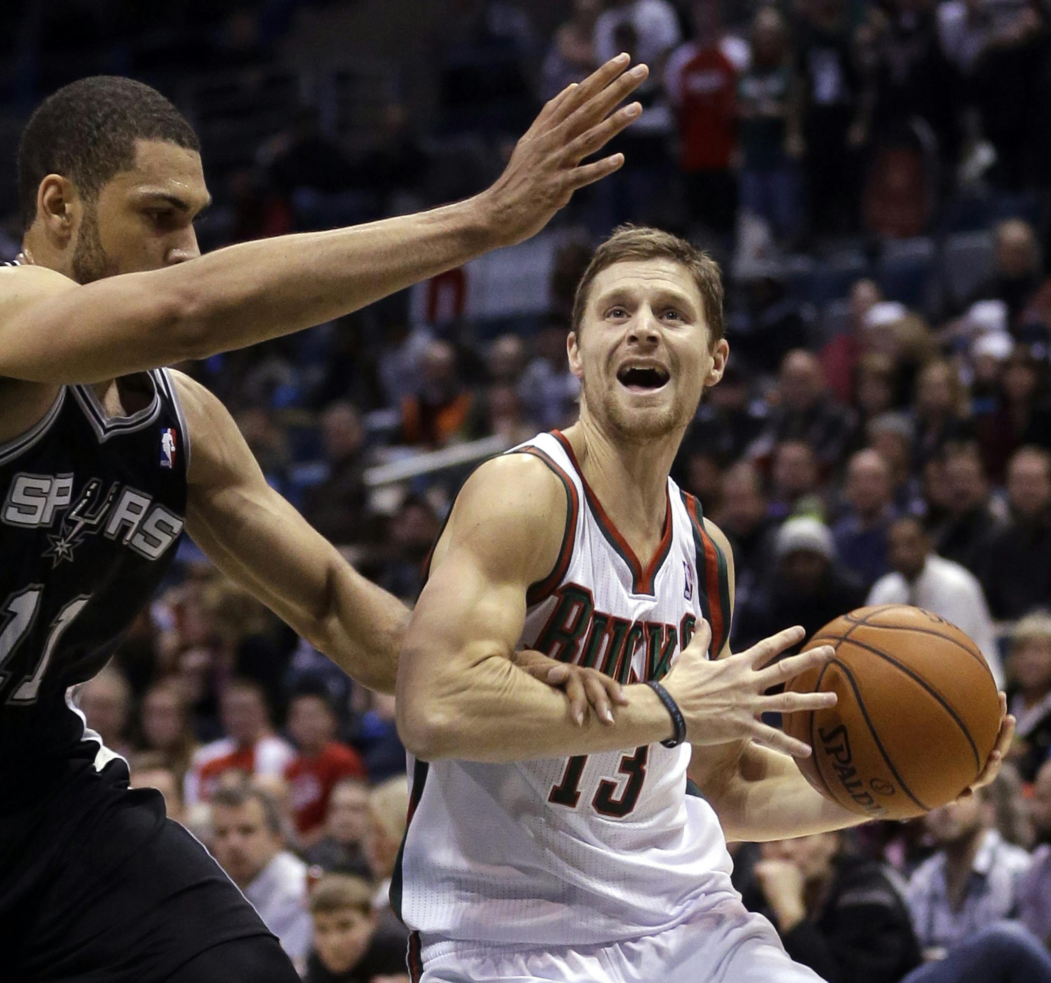 Milwaukee Bucks' Luke Ridnour(13) is fouled by San Antonio Spurs' Jeff Ayres(11) as he drives during the first half of an NBA basketball game Wednesday, Dec. 11, 2013, in Milwaukee. (AP Photo/Morry Gash)