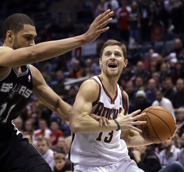 Milwaukee Bucks' Luke Ridnour(13) is fouled by San Antonio Spurs' Jeff Ayres(11) as he drives during the first half of an NBA basketball game Wednesda