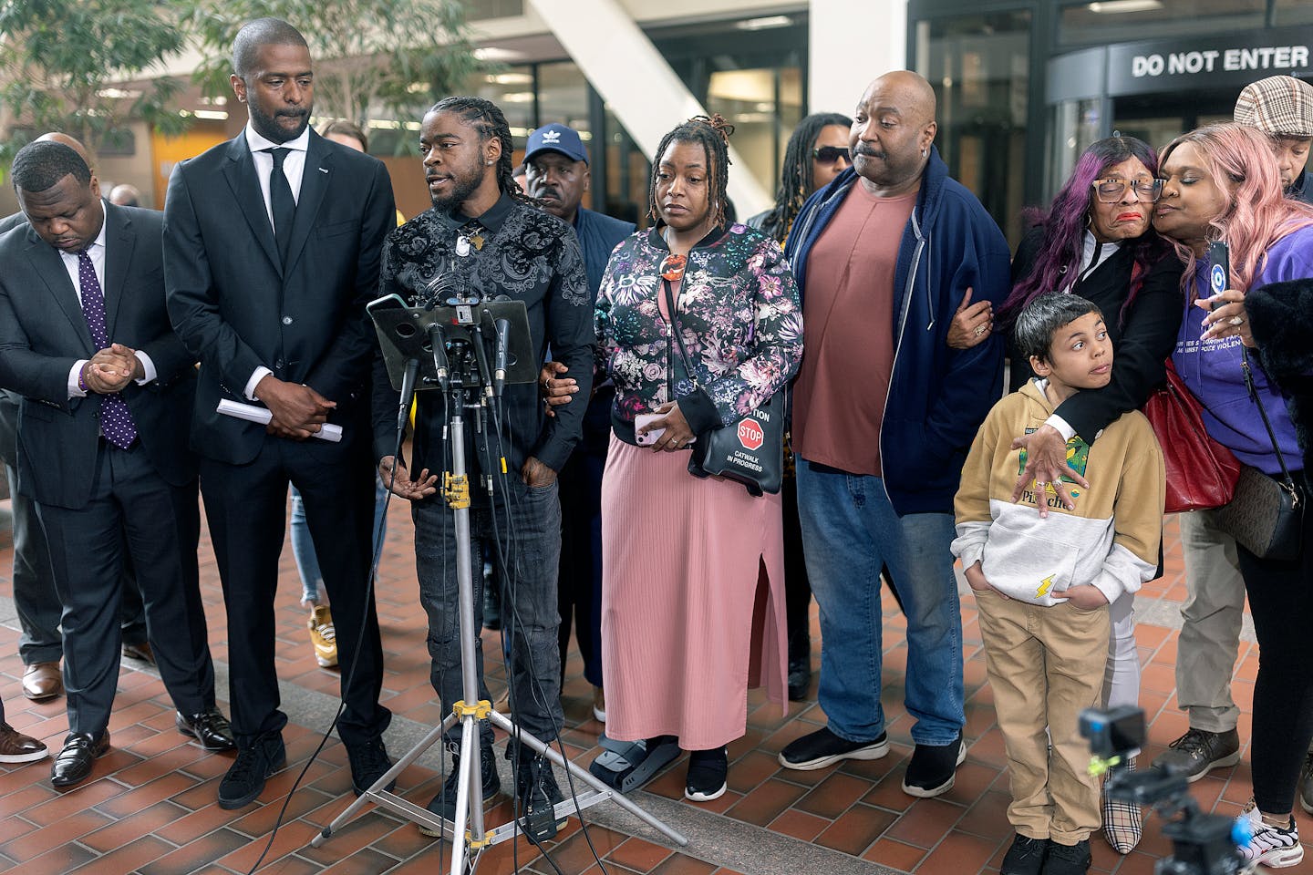 Surrounded by lawyers and family, Ricky Cobb’s twin brother Rashad Cobb, center, addresses the media about the lawsuit the family is filing against 