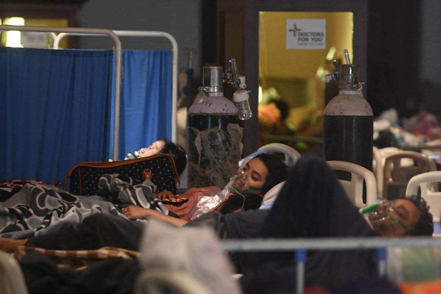 Patients breath with the help of oxygen masks inside a banquet hall temporarily converted into a Covid-19 coronavirus ward in New Delhi on April 27, 2021. (Photo by MONEY SHARMA/AFP via Getty Images/TNS) ORG XMIT: 15030216W