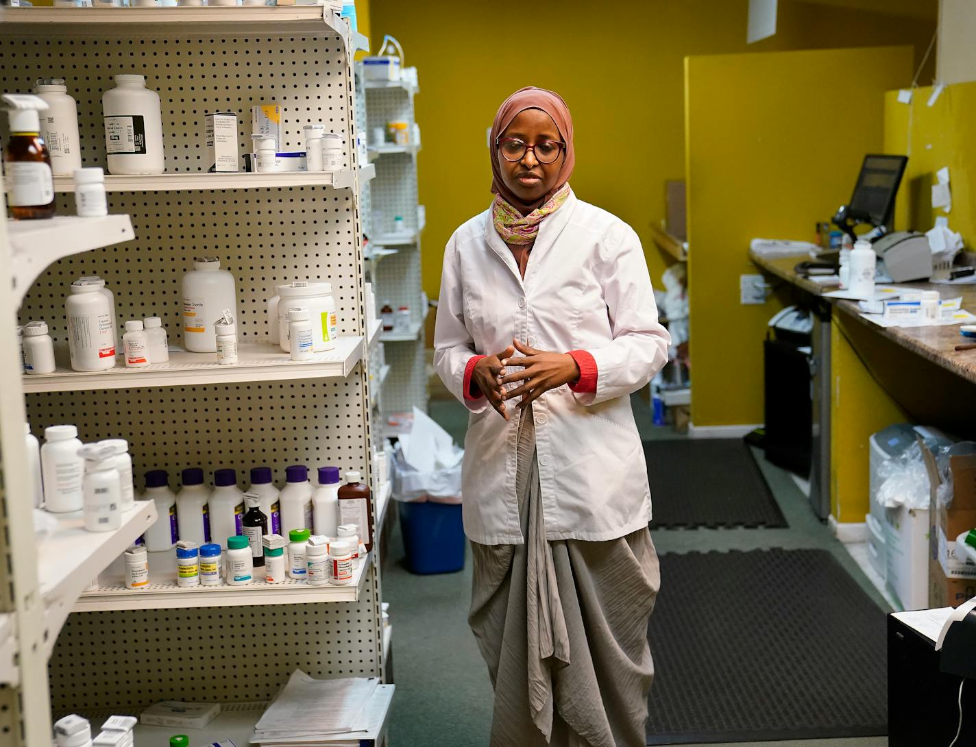 Saida Mohamed, owner and pharmacist at Lake Cedar Pharmacy, was again the target of looters this week during civil unrest — the second time her business has been looted in the last year and seen Thursday in Minneapolis. Mohamed, who has owned her business for 10 years, said she is fatigued and traumatized and questions whether she can survive another attack. Here, Mohamed stood for a portrait inside her business. ]