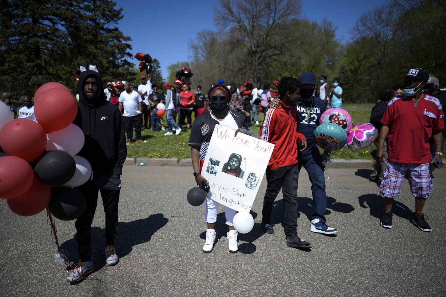 Brittany Lee, niece of Douglas Lewis, held a poster with photos of her uncle Doug during a memorial for Lewis in St. Paul on May 3.