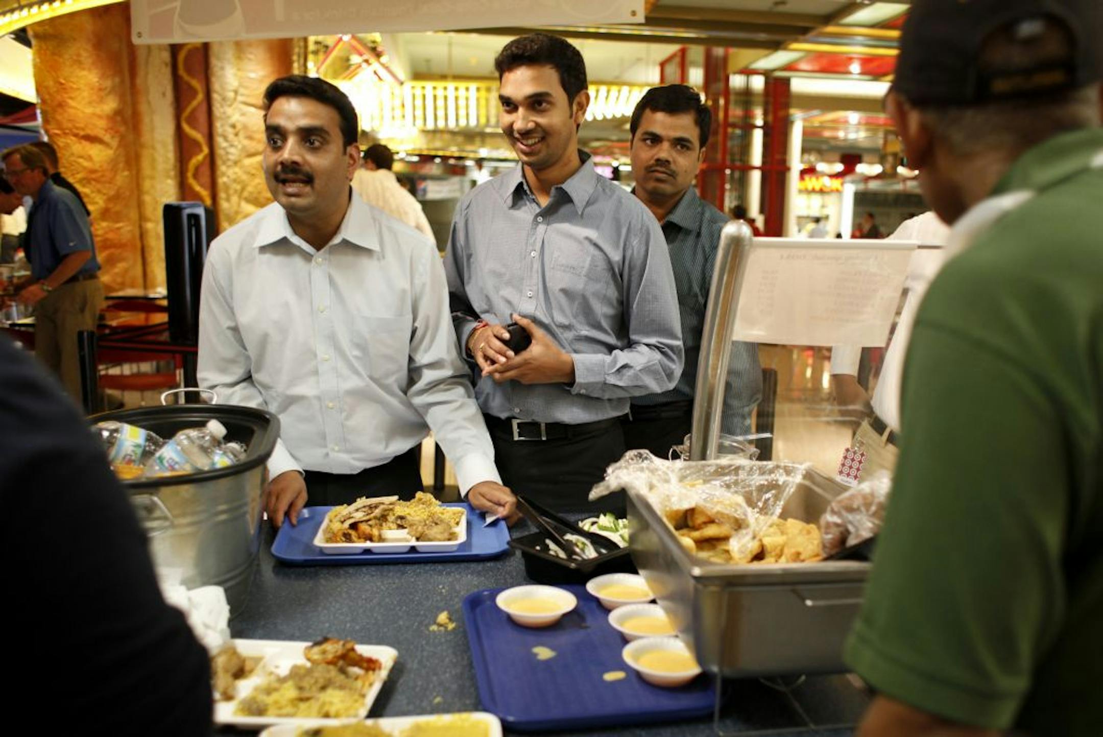 Co-workers Rajeev Gupta, left, Prashanth Gubbala and Purushotham Thenepalli bought lunch at Kabobs Indian Grill on Tuesday at Gaviidae Common in Minneapolis. The three, IT professionals at Target, all hold master's degrees in computer science.