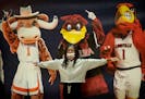 A young basketball fan posed with college mascots at the Capital One Women's Final Four activities at the Convention Center in Minneapolis.