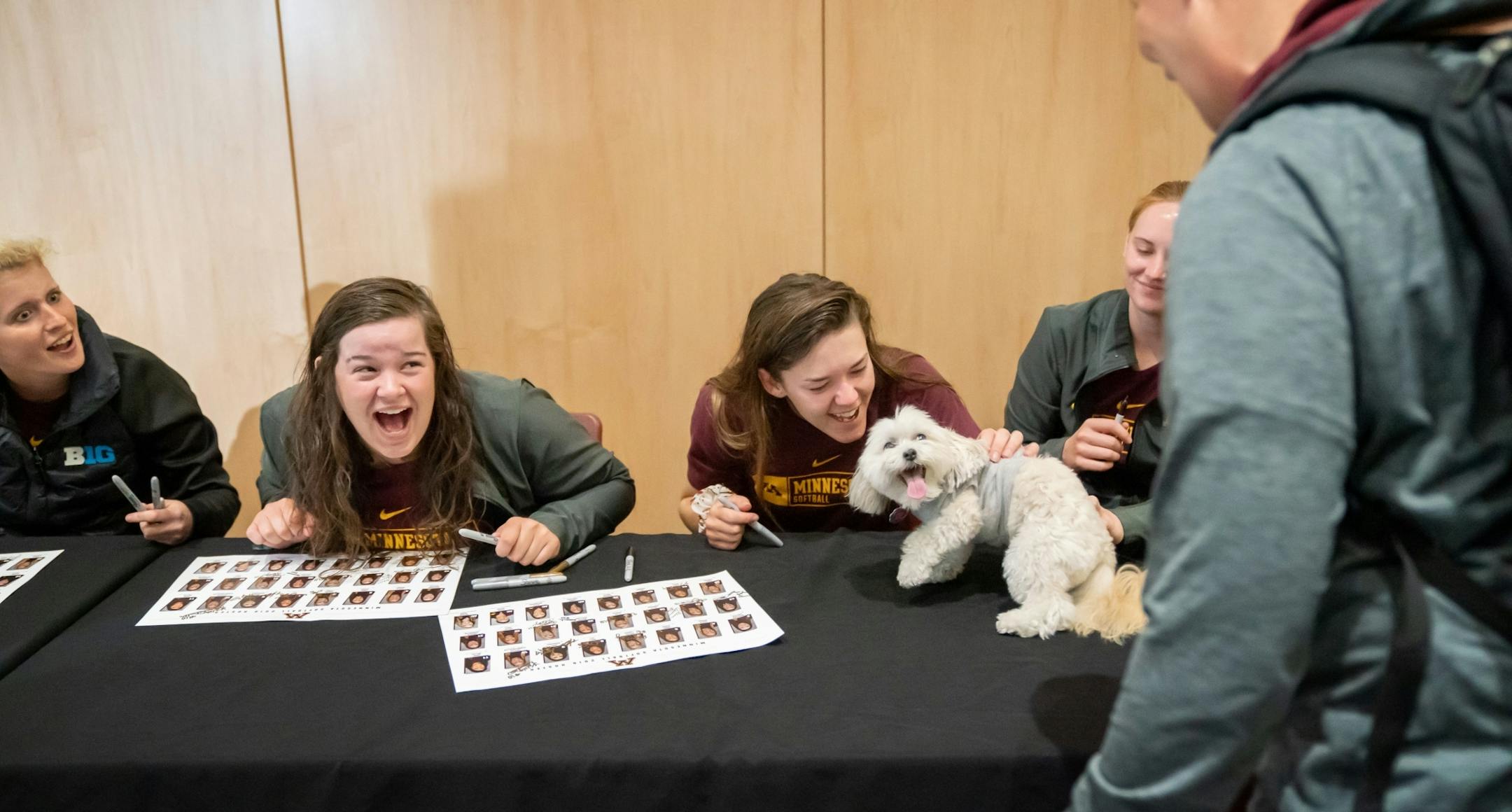 Kaylen Krueger, Sydney Smith, Makenna Partain and Taylor Chell loved it when Dixie Rose, who belongs to super fan Sandy Fuchs, walked along the table to bring the players good luck.