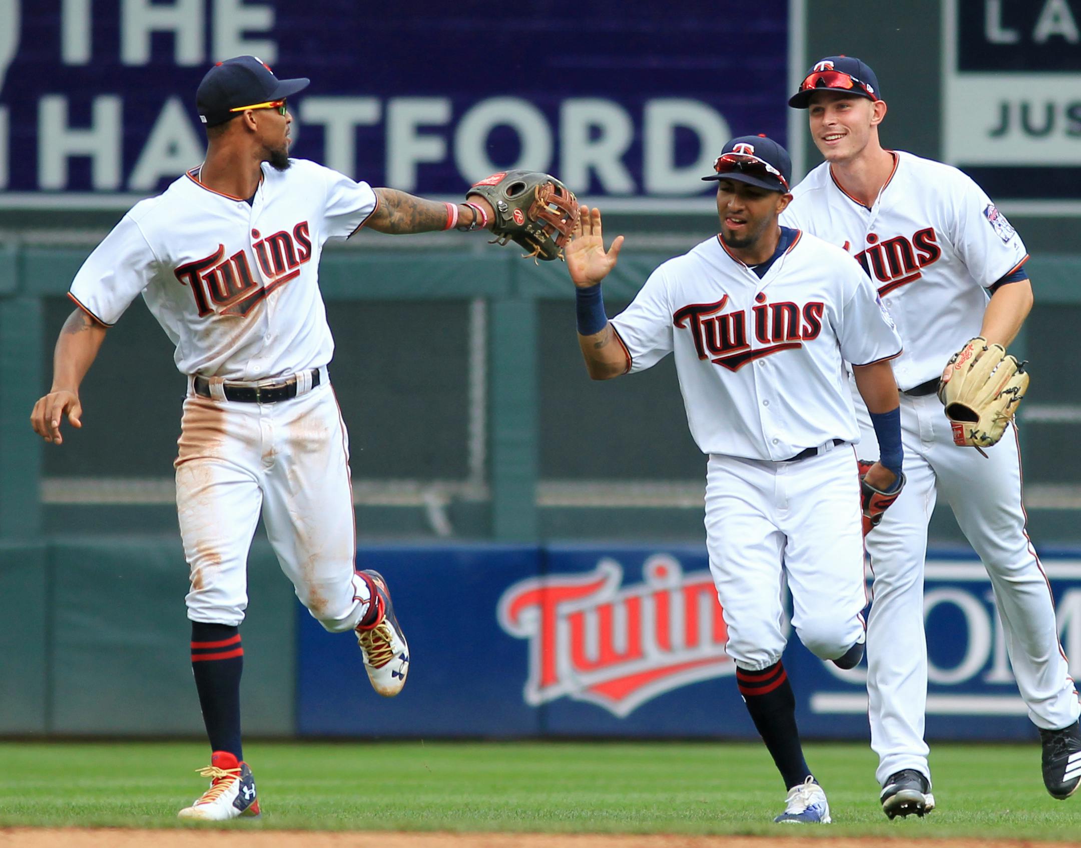 Minnesota Twins outfielders Byron Buxton (25), Eddie Rosario (20) and Max Kepler (26) celebrate after defeating the Texas Rangers during a baseball game on Sunday, Aug. 6, 2017, in Minneapolis. The Twins defeated the Rangers 6-5. (AP Photo/Andy Clayton-King)