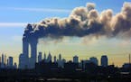FILE - In this Sept. 11, 2001 file photo, as seen from the New Jersey Turnpike near Kearny, N.J., smoke billows from the twin towers of the World Trad