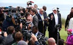 US presidential candidate Donald Trump, right, chats with the watching media whilst on a tour of the Trump International Golf Links at Balmedie, near 
