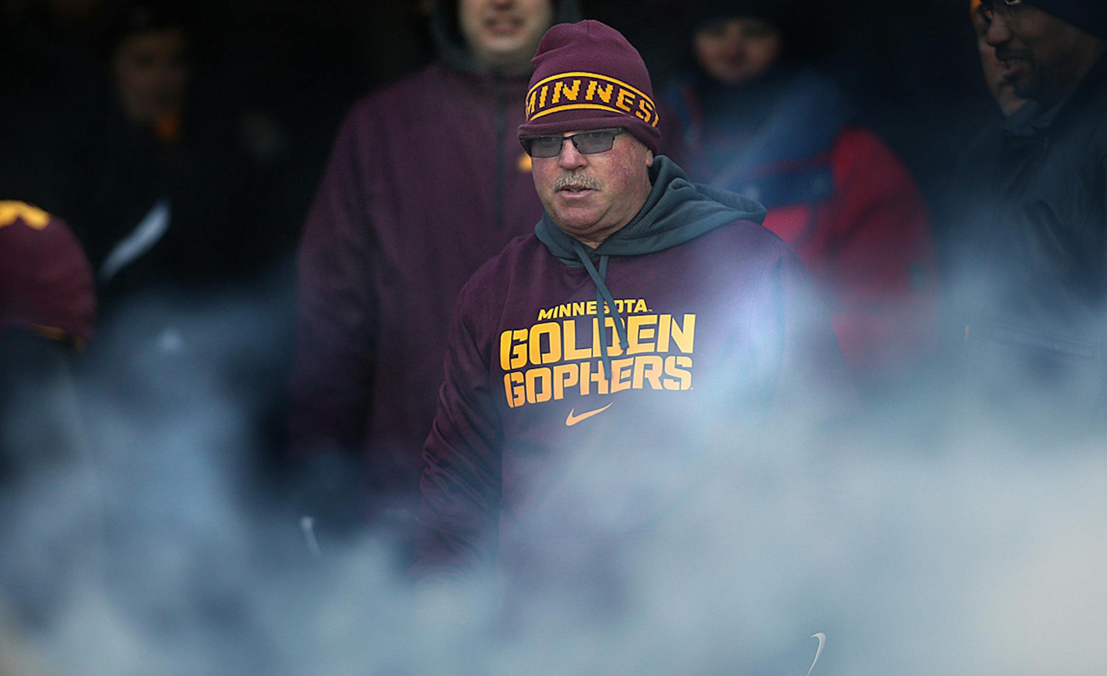 Smoke swirled around Gophers head coach Jerry Kill as he watched senior players as they were introduced before the game. Against Wisconsin.