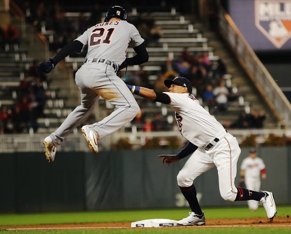 The Minnesota Twins' Ehire Adrianza tags out the Detroit Tigers' JaCoby Jones (21) at third base in the third inning at Target Field in Minneapolis on