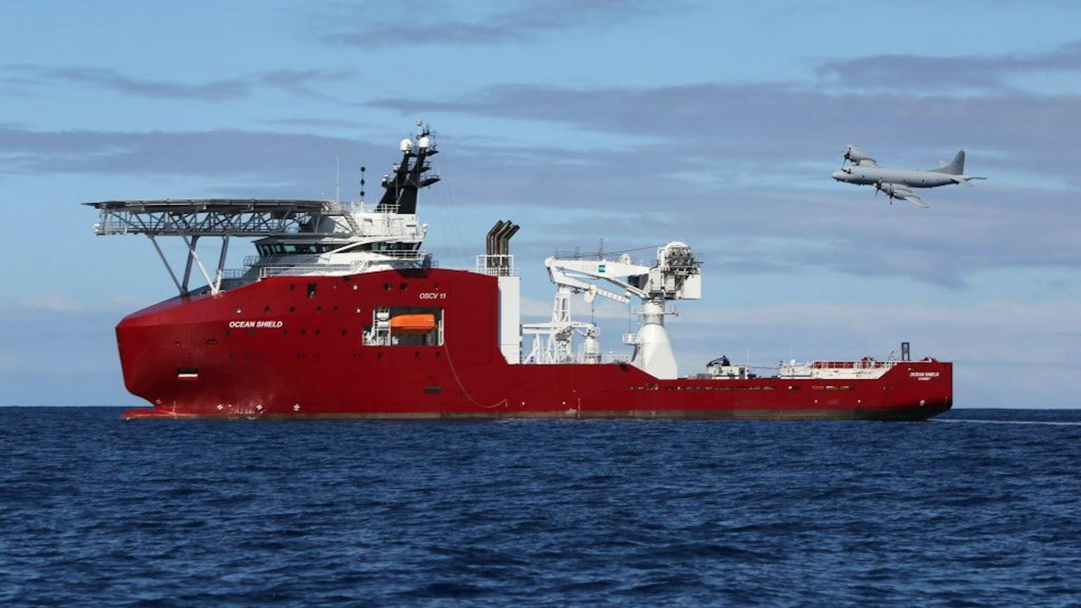 FILE - In this April 9, 2014 file photo provided by the Australian Defense Force, a Royal Australian Air Force AP-3C Orion flies past Australian Defense vessel Ocean Shield on a mission to drop sonar buoys to assist in the acoustic search of the missing Malaysia Airlines Flight MH370 in the southern Indian Ocean.