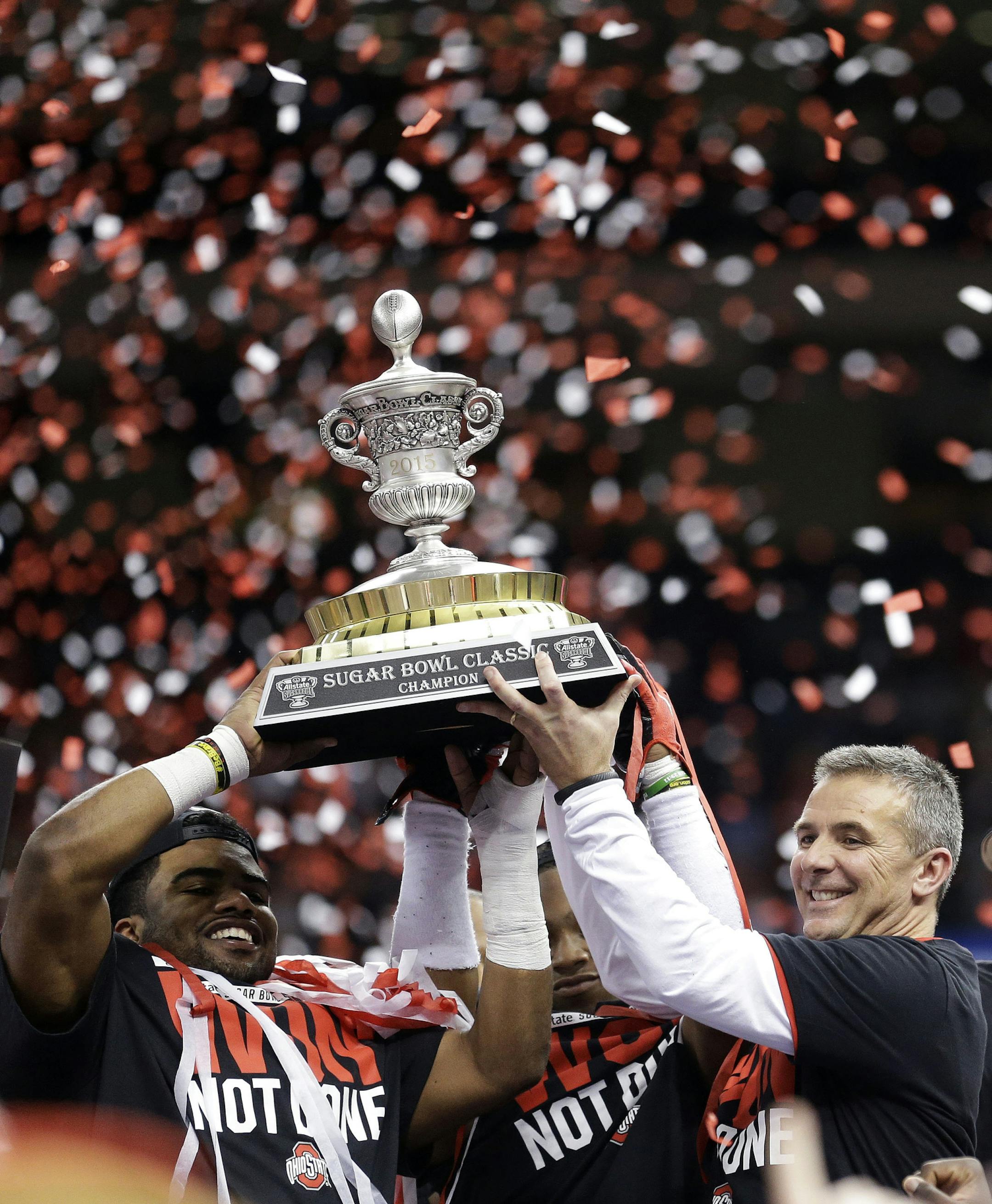 Ohio State players and staff hold the Sugar Bowl Classic trophy after their 42-35 win over Alabama in the Sugar Bowl NCAA college football playoff semifinal game early Friday, Jan. 2, 2015, in New Orleans. The Big Ten, with not much to brag about in recent bowl seasons, is puffing out its chest after a New Year's Day in which Ohio State beat Alabama in a national semifinal and Michigan State and Wisconsin produced dramatic victories. (AP Photo/Brynn Anderson)