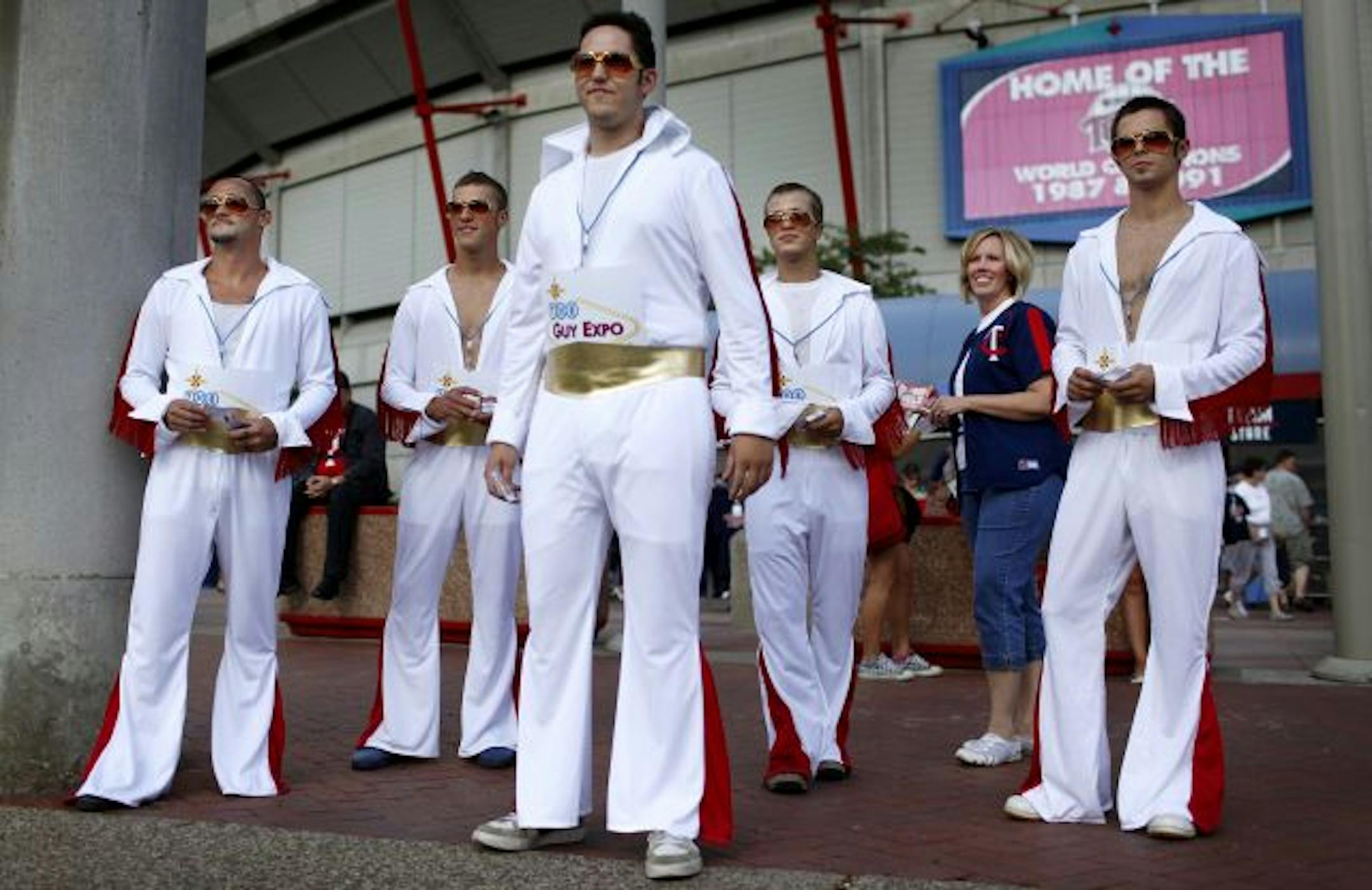 With her entourage of helpers each dressed as Elvis Shawna Suckow, creator of The Guy Expo, hands out coupons to the upcoming event during the Twins game Tuesday evening outside the Metrodome.