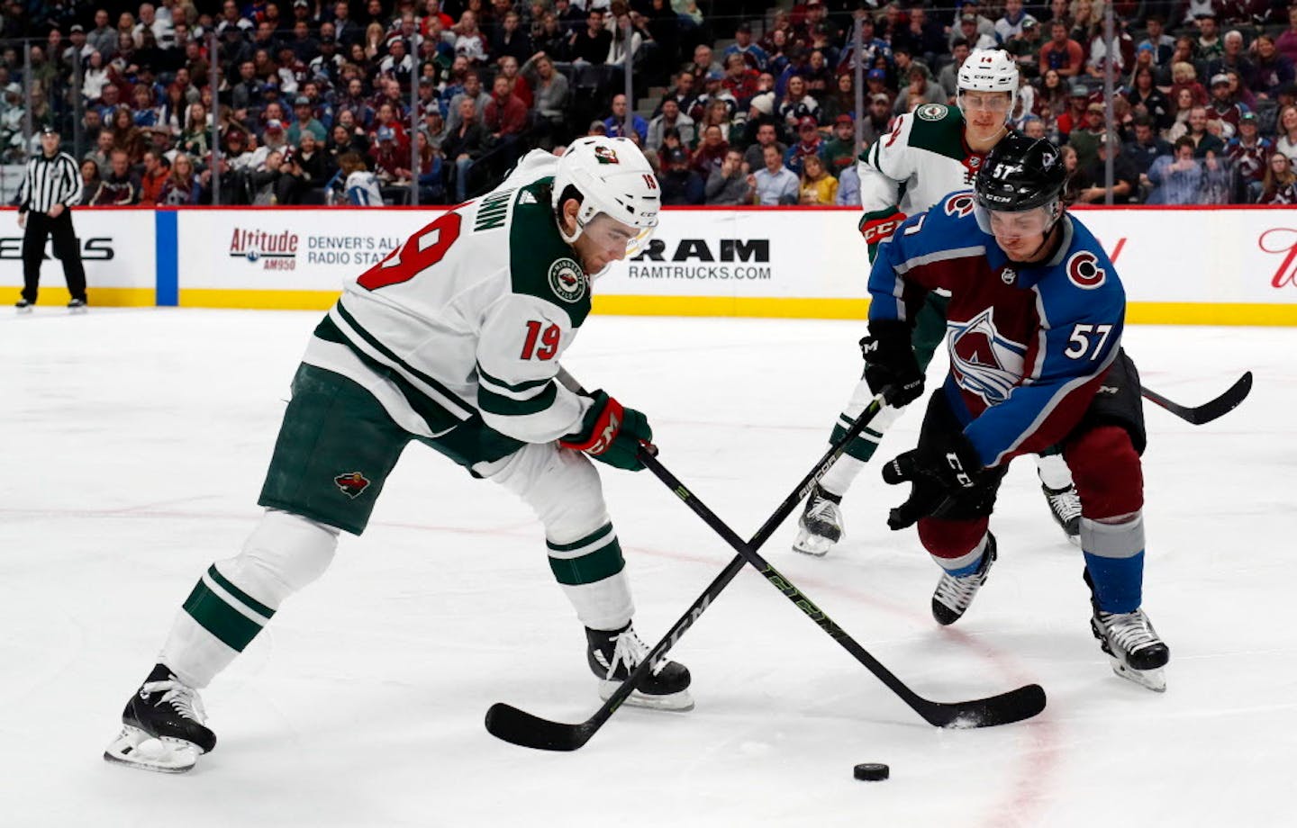 Minnesota Wild center Luke Kunin, left, reaches for the puck as Colorado Avalanche left wing Gabriel Bourque defends during the third period of an NHL hockey game Friday, March 2, 2018, in Denver. The Avalanche won 7-1.