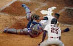 Luis Arraez scrambles back to touch home plate after a collision with Rangers catcher Jose Trevino during the Twins’ 6-5 victory on Monday. The play