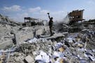 A Syrian soldier films the wreckage of the Syrian Scientific Research Center, which was attacked by U.S., British and French military strikes to punis