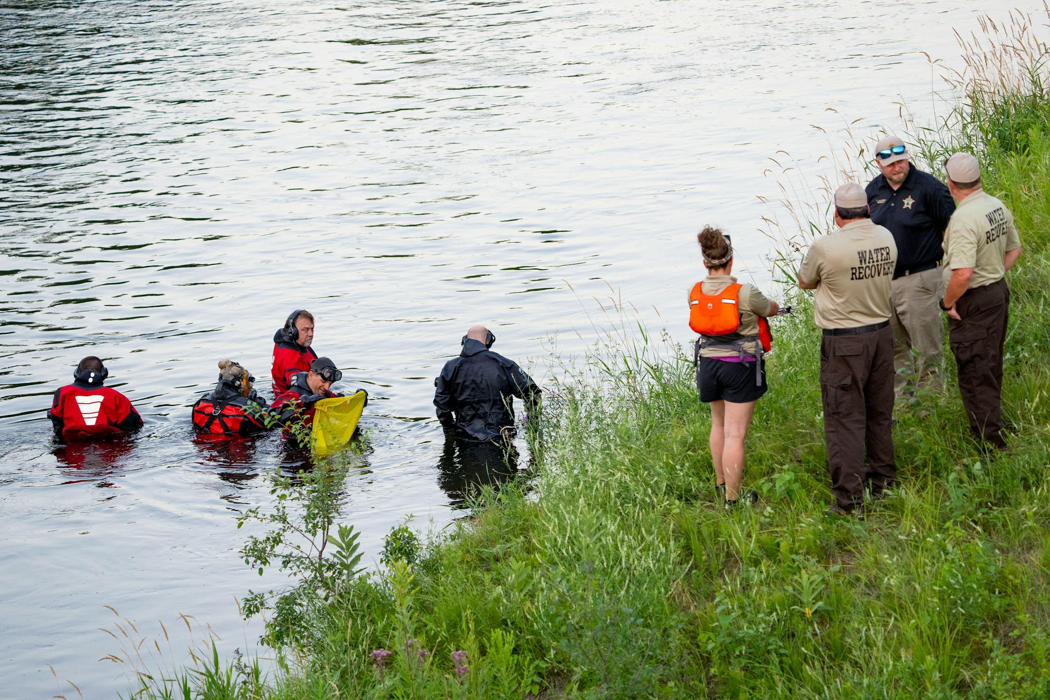 Water Recovery authorities comb the Apple River with metal detectors after five people were stabbed while tubing down the river Saturday, July 30, 2022 in Somerset, WI. ]