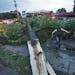 Storm damage in St. Paul - tree down across Larpenteur Ave. at Dale Street. Heidi Lee, left, and Sarah Reiter examined the tree that split from its tr