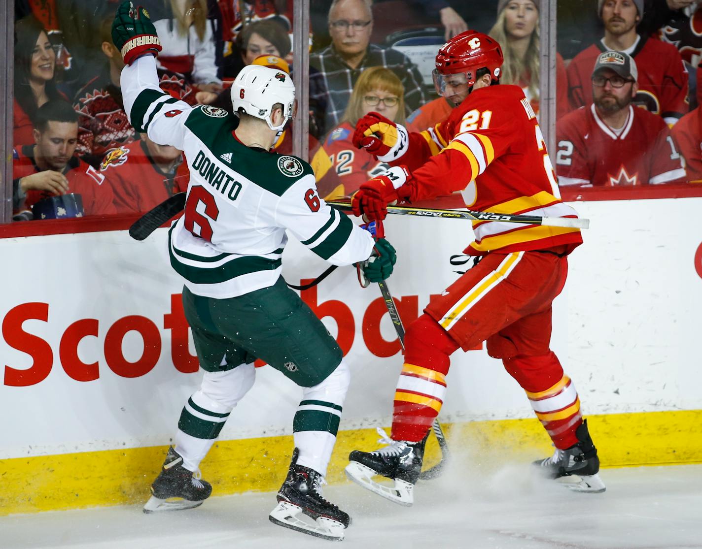 The Wild's Ryan Donato, left, is checked by Calgary Flames' Garnet Hathaway during the first period