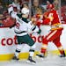 The Wild's Ryan Donato, left, is checked by Calgary Flames' Garnet Hathaway during the first period