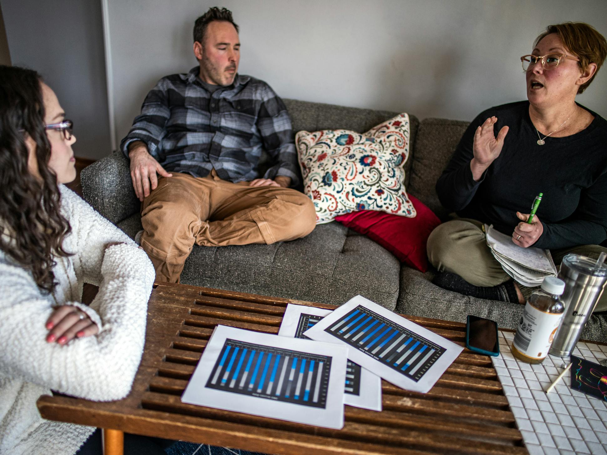 Behavior analyst Randal Westergard, left, discussed Harrison's progress with his parents at their home in West St. Paul. At-home care has helped him thrive.